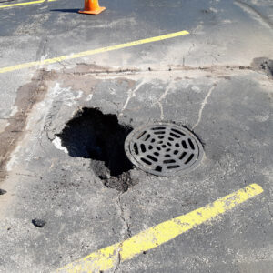 Damaged asphalt with pothole repair