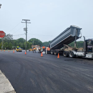 Dump truck paving new asphalt road